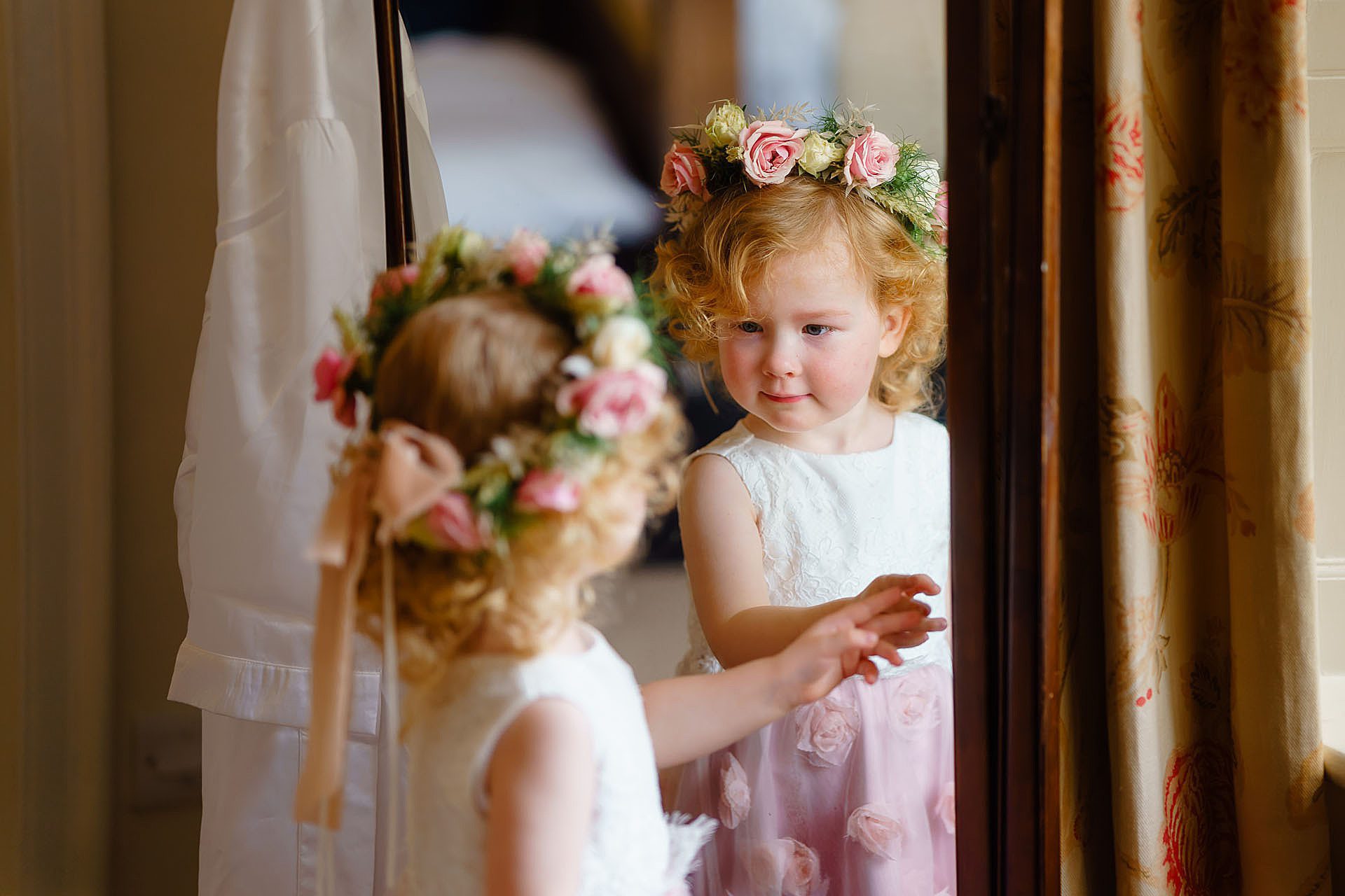 flower girl looking at herself in the mirror