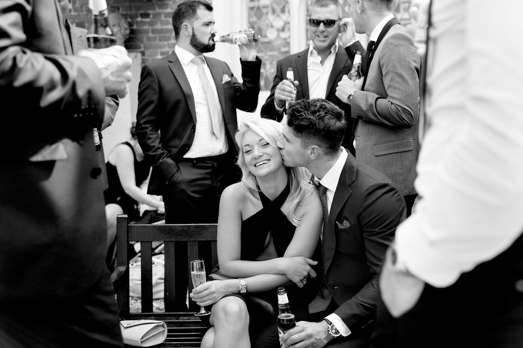 People in formal attire at a celebratory social event, with drinks, chatting and smiling.
